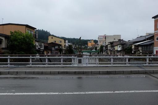 雨の鍛冶橋の欄干と歩道と宮川と高山の街並 雨の鍛冶橋の欄干と歩道と宮川と高山の街並の写真