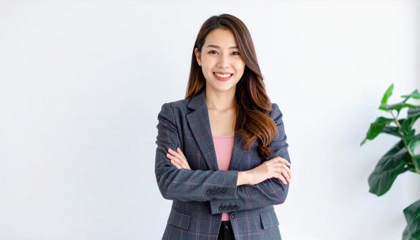 腕組みするスーツ姿のビジネスウーマン 腕組みするスーツ姿のビジネスウーマンの写真