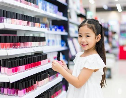 マニキュアなど化粧品を手に取る日本人少女 マニキュアなど化粧品を手に取る日本人少女の写真
