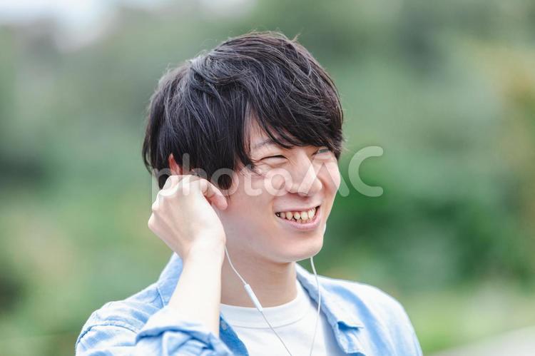 イヤホンをつけた笑顔の男性　 男性,イヤホン,笑顔の写真素材