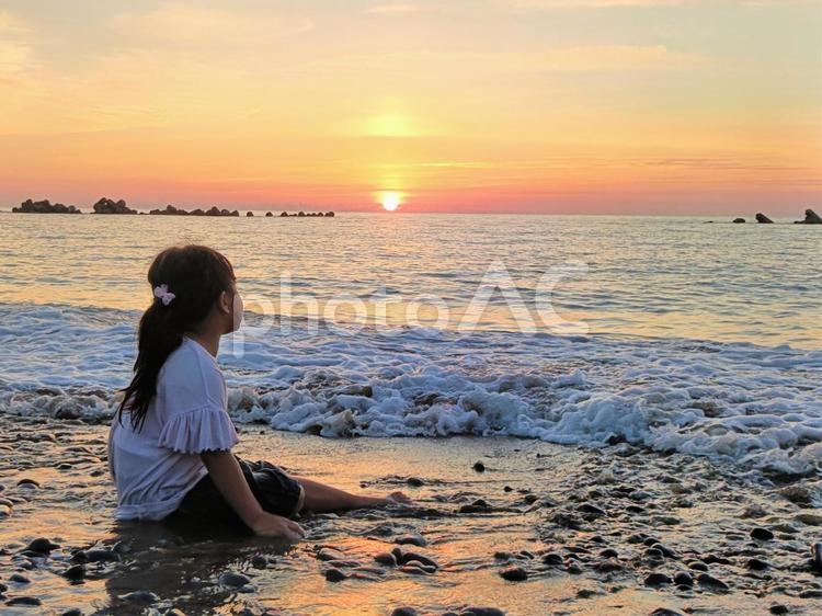 日本海に沈む夕日を眺める女の子4 日本海,海,夕陽の写真素材