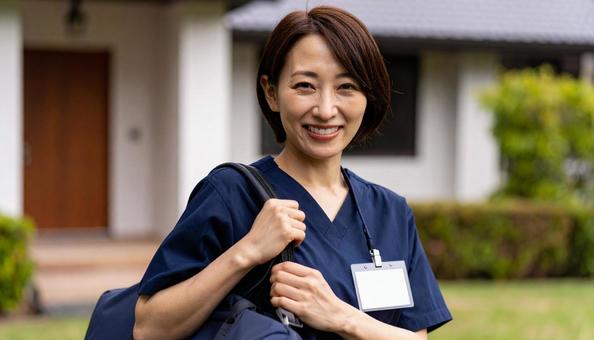 訪問看護で訪問先の住宅に笑顔で立つ女性 訪問看護で訪問先の住宅に笑顔で立つ女性の写真