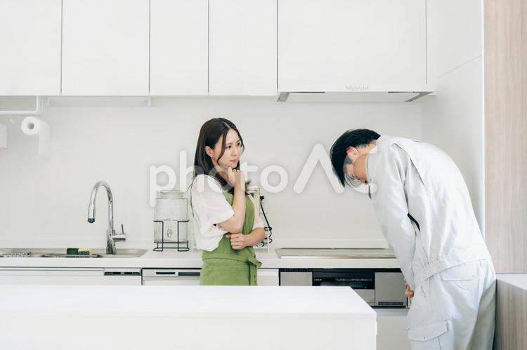 謝罪する作業着の男性と女性 瑕疵住宅,欠陥住宅,謝罪の写真素材