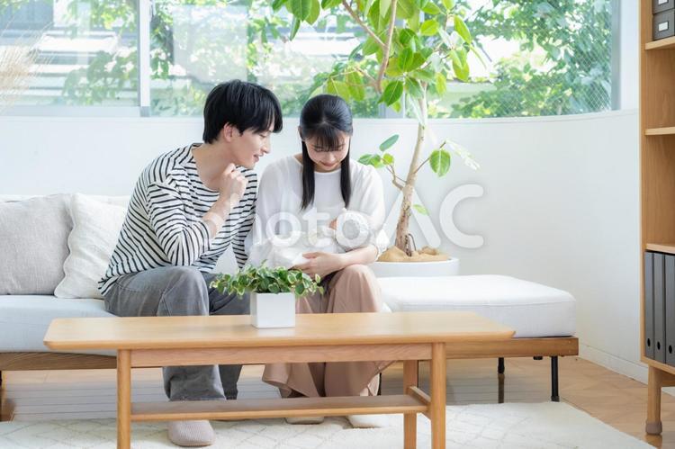 リビングで赤ちゃんを抱く若い家族 家族,親子,赤ちゃんの写真素材