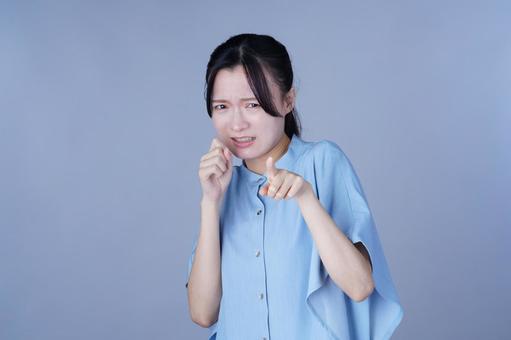 指差ししている青い服の女性の写真