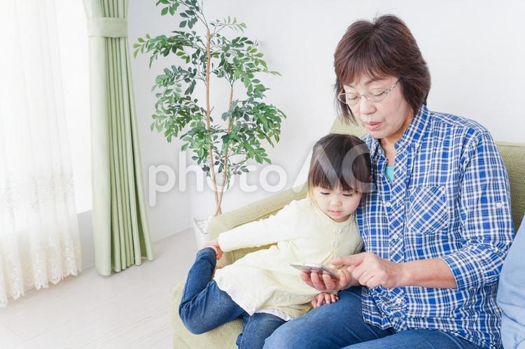 おばあちゃんとスマホを使う子供 タッチパネル,ゲーム,かわいいの写真素材
