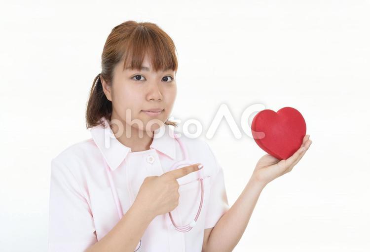 ハート型のオブジェを持つ看護師 女性,看護師,看護士の写真素材