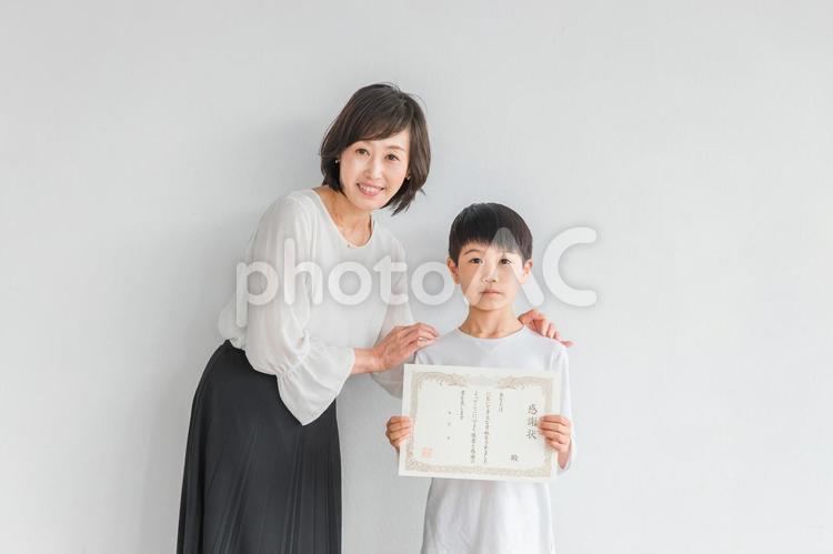 感謝状を持つ子供と女性（先生・ママ） 感謝状,小学生,賞状の写真素材