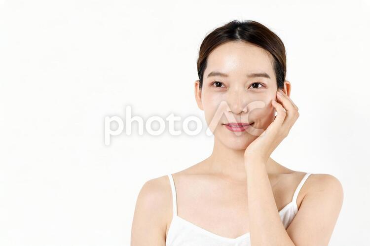 スキンケアをする女性のイメージ 女性,顔,白バックの写真素材