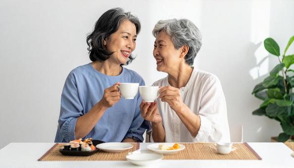 お茶を飲むシニアとミドル女性 お茶を飲むシニアとミドル女性の写真