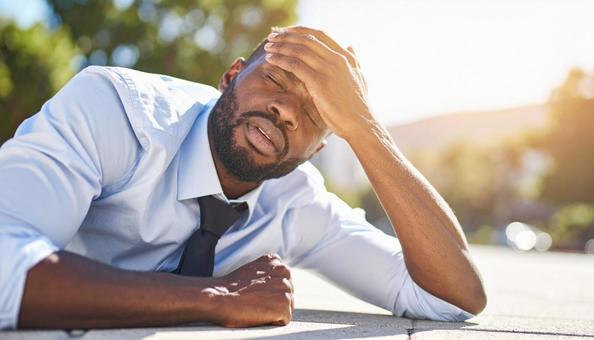 暑さでダウンし、倒れる込む外国人男性 暑さでダウンし、倒れる込む外国人男性の写真