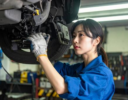 自動車工場でエンジン整備する女性スタッフ 自動車工場でエンジン整備する女性スタッフの写真