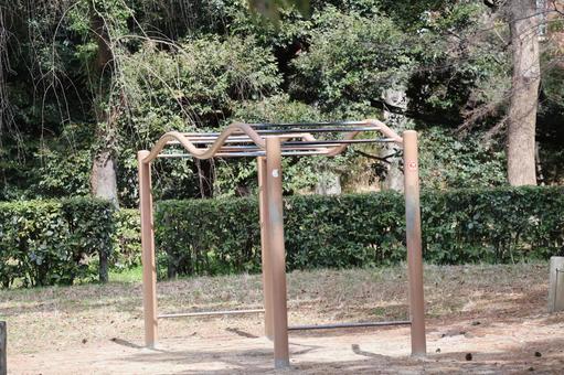 A park surrounded by trees and featuring a climbing ladder, JPG