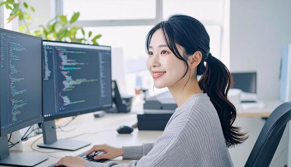 プログラミングをする女性エンジニア プログラミングをする女性エンジニアの写真