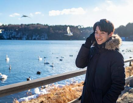 冬の湖・白鳥を観察する彼 冬の湖・白鳥を観察する彼の写真