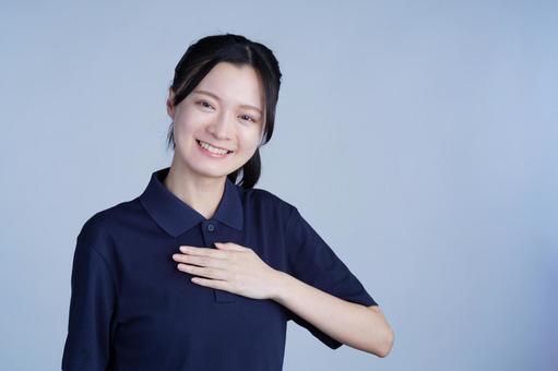 紺色の服の女性が胸に手を当てる 女性,笑顔,にっこりの写真素材