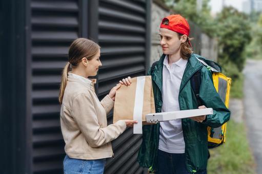 フードデリバリーの男性から料理を受け取っている女性 配達,フードデリバリー,デリバリーの写真素材