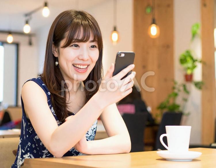 カフェでスマートフォンを操作する女性 カフェ,スマホ,スマートフォンの写真素材
