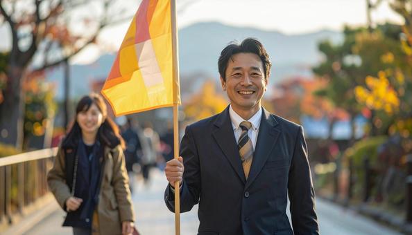 旗を持って旅行客を導く男性の旅行添乗員 旗を持って旅行客を導く男性の旅行添乗員の写真