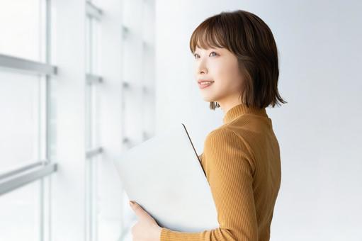 パソコンを持つ女性・ビジネスウーマン パソコンを持つ女性・ビジネスウーマン 女性,パソコン,笑顔の写真素材