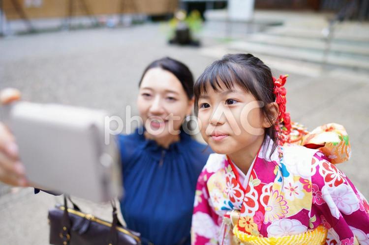 着物姿の娘と笑顔で写真を撮る母親 七五三,お参り,七五三参りの写真素材
