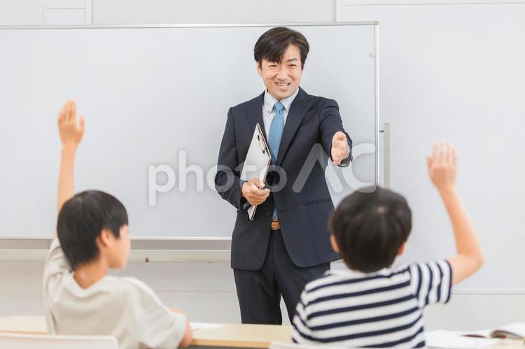先生と積極的に挙手する小学生の生徒 先生,教師,塾の写真素材
