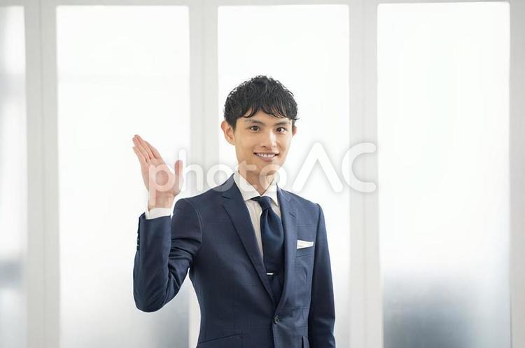 手でサービスを案内するビジネスマン 男性,ビジネスマン,案内の写真素材