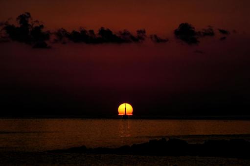 <素材>秋の海に沈む太陽と沖の灯台 <素材>秋の海に沈む太陽と沖の灯台の写真