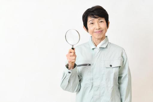 虫眼鏡を持つカメラ目線の作業服の中年女性 作業員,虫眼鏡,ミドルの写真素材