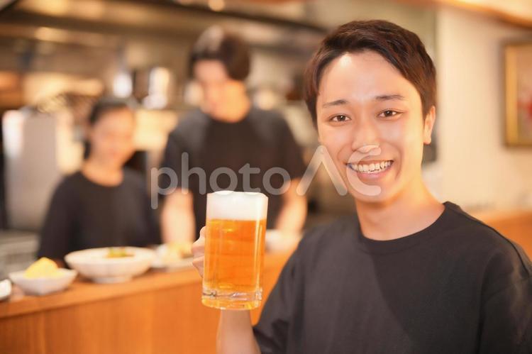 カウンターでビールを持った店員 男女,大学生,店員の写真素材