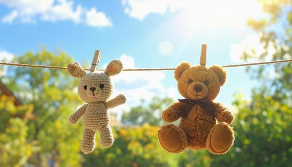 洗濯後に干される熊とウサギのぬいぐるみ 洗濯後に干される熊とウサギのぬいぐるみの写真
