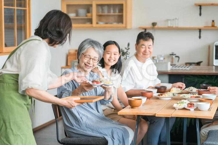 食事する子供と夫婦・親子・三世代家族 家族,子供,食事の写真素材
