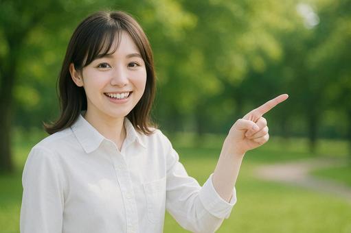 公園で指差す女性 公園で指差す女性の写真