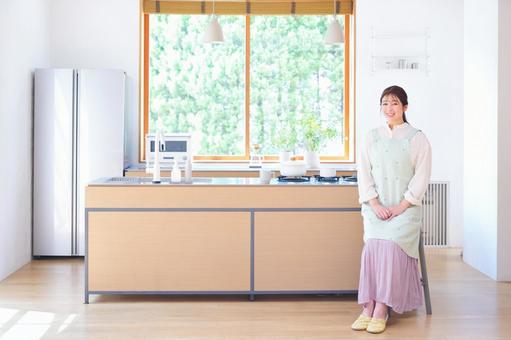 キッチンで座る笑顔の女性 キッチンで座る笑顔の女性 女性,笑う,笑顔の写真素材