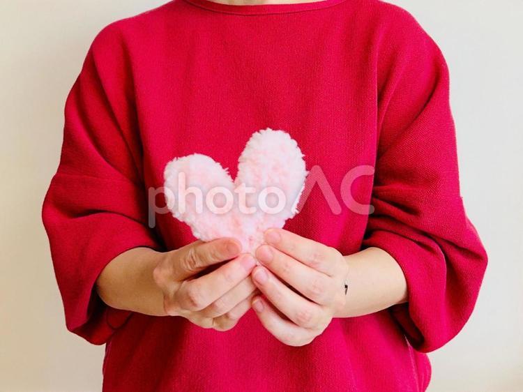 ピンクのハートを両手で持つ女性 ハート,女性,上半身の写真素材
