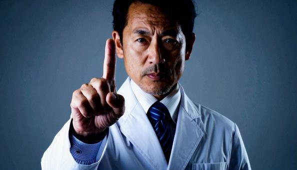 注意! 人差し指を立てる白衣を着た男性 注意! 人差し指を立てる白衣を着た男性の写真
