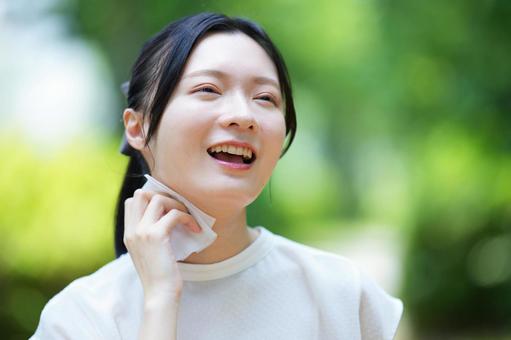 女性がハンカチを手を頬に添えて笑うの写真