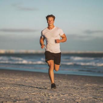波打ち際を走る男性ランナー 波打ち際を走る男性ランナーの写真