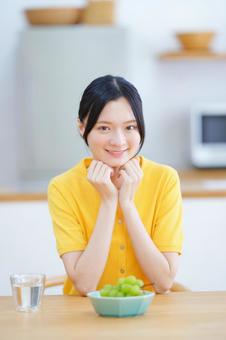 カメラ目線で頬杖をする女性の写真