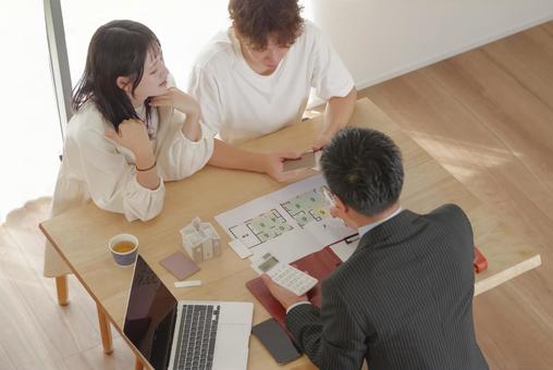 営業マンと家づくりの相談をする若い夫婦 営業マンと家づくりの相談をする若い夫婦 住宅,家,新築の写真素材