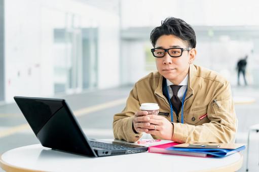 パソコンの前でドリンクを飲む男性作業員 パソコンの前でドリンクを飲む男性作業員 ビジネス,ビジネスマン,作業員の写真素材