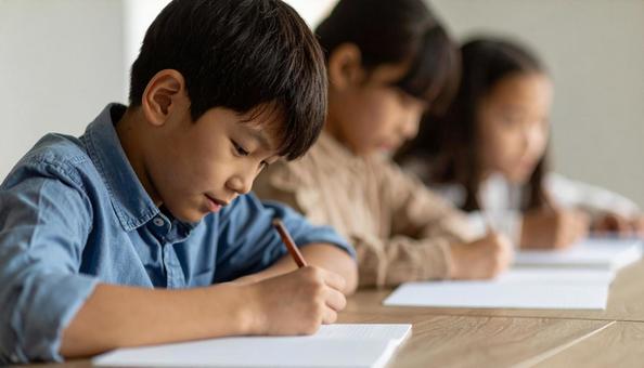 塾で勉強する日本人の小学生3人 塾で勉強する日本人の小学生3人の写真
