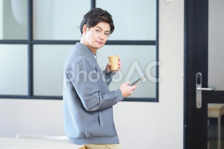 スマホを持ち振り向く男性 男性,振り向く,スマートフォンの写真素材