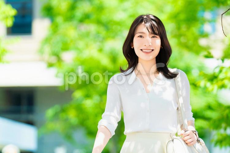 屋外を歩く笑顔の女性・ビジネスウーマン 女性,歩く,夏の写真素材