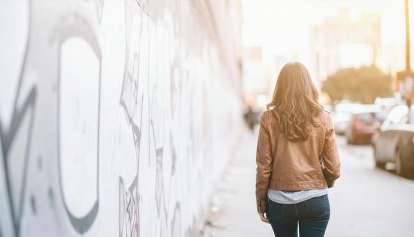 街を歩く女性の後ろ姿の写真