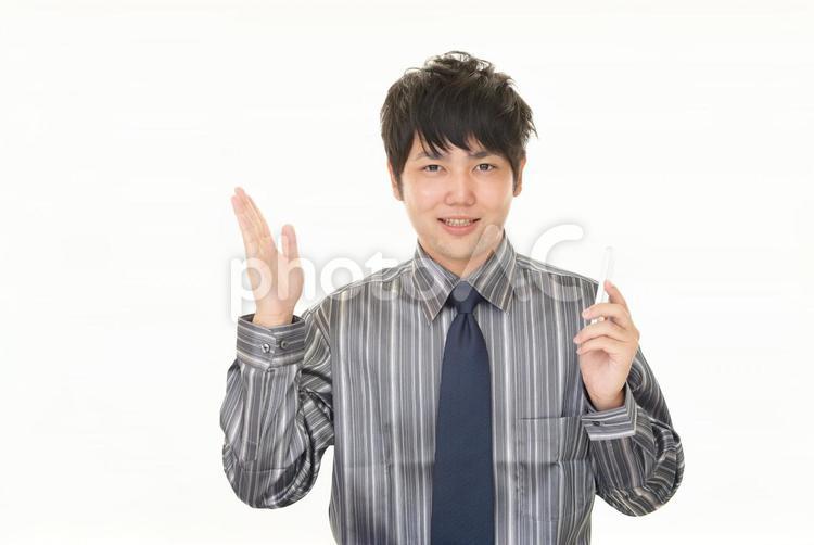 スマホを持って案内するビジネスマン 男性,スマホ,ビジネスの写真素材