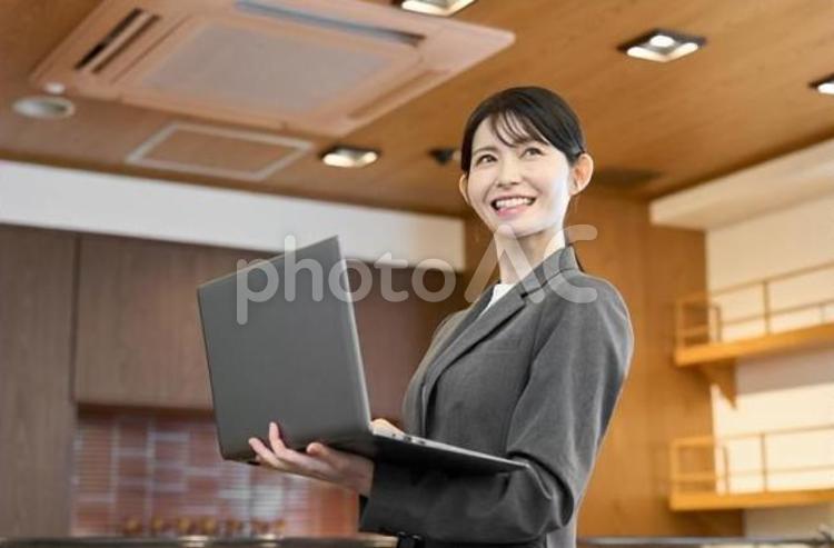 飲食店でパソコンを見るスーツを着た女性 飲食店,女性,ノートパソコンの写真素材