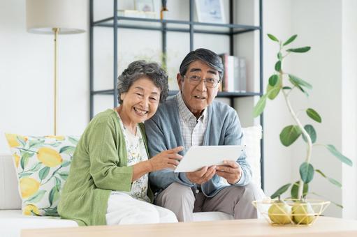 リビングでタブレットを使うシニアの夫婦 リビングでタブレットを使うシニアの夫婦 シニア,夫婦,タブレットの写真素材