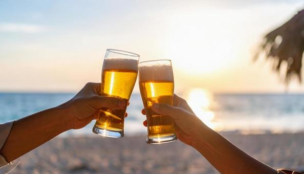 海辺でビールで乾杯をする手 海辺でビールで乾杯をする手の写真