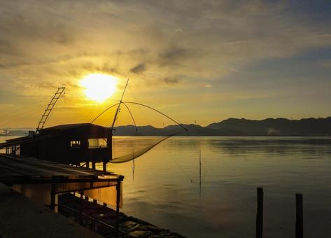 朝焼けにシルエットになる四手網の小屋 朝日,朝焼け,四つ手網の写真素材